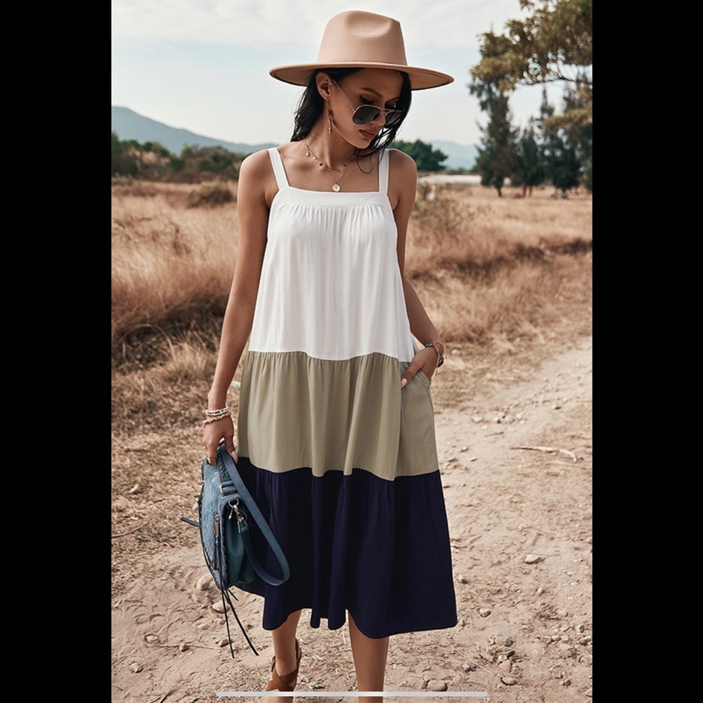Dark navy, tan, white sleeveless color block ruffle dress.